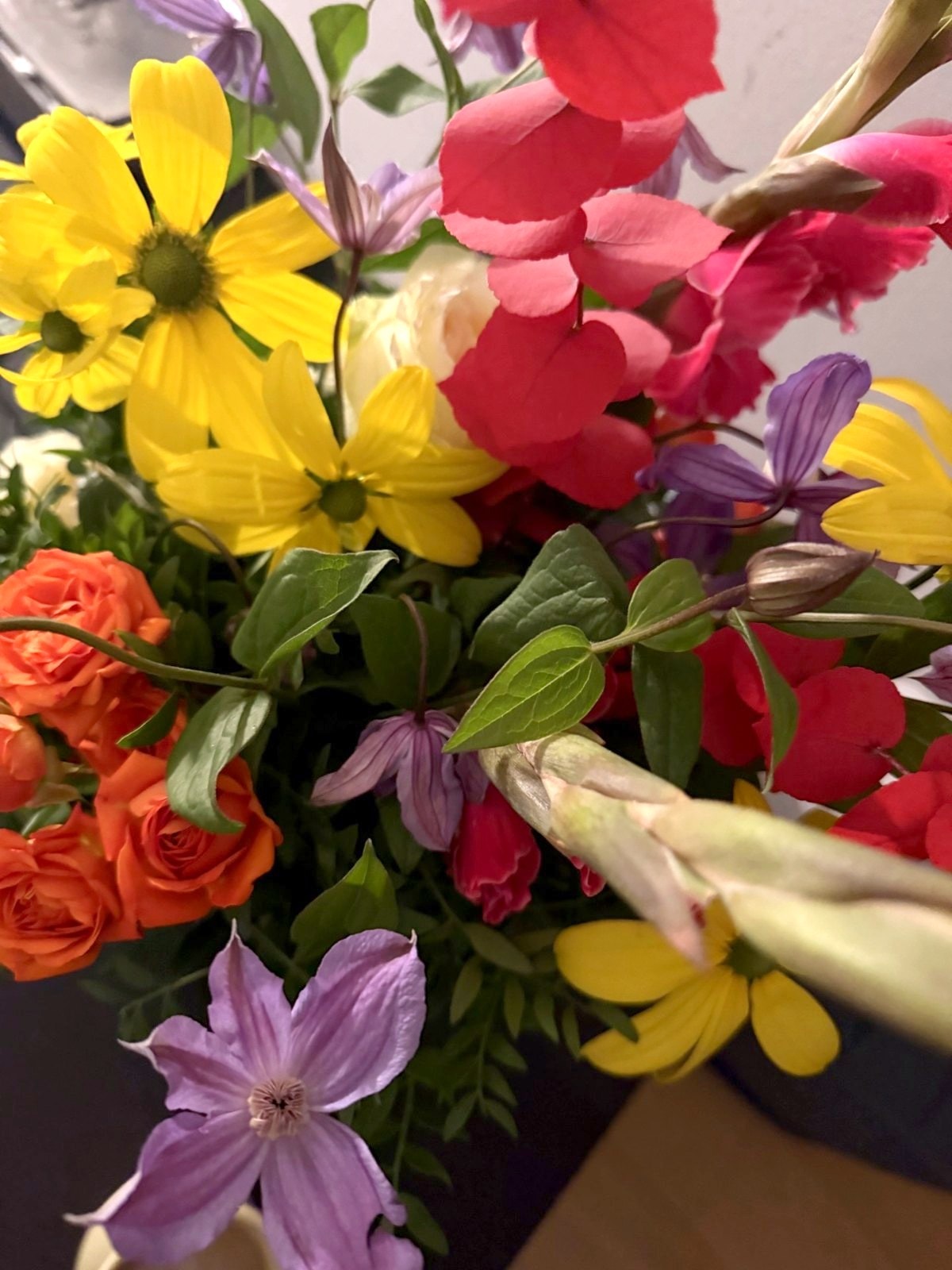 Farverig buket med gule, røde og lilla blomster fra receptionen